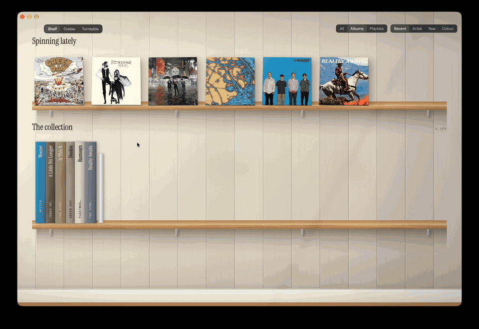Screen recording of the app's Turntable view: a record spinning on a record player on a wooden desk while it plays from Spotify.